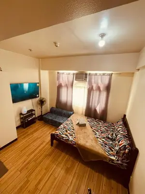 a bedroom with a bed and a couch at JFam Suites, C4-10R Studio, Up To 4 Pax in Biñan