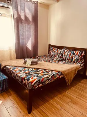a bed sitting in a room with a window at JFam Suites, C4-10R Studio, Up To 4 Pax in Biñan