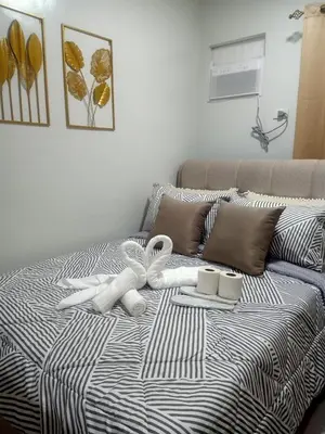 a bed with two white towels on top of it at Coho Staycation with Free swimming in Las Pinas in Manila