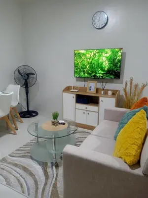 a living room with a couch and a flat screen tv at Coho Staycation with Free swimming in Las Pinas in Manila