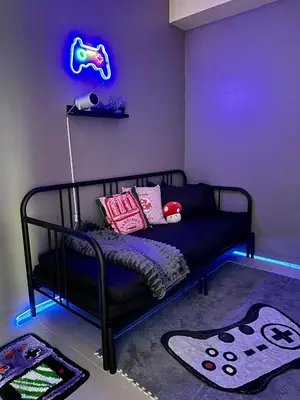 a room with a black bed with a neon sign at RoVi,s Nook SMDC Charm in Manila