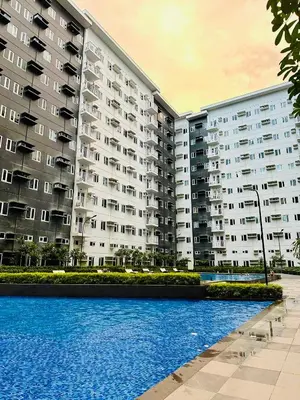 a large apartment building with a pool in front of it at RoVi,s Nook SMDC Charm in Manila