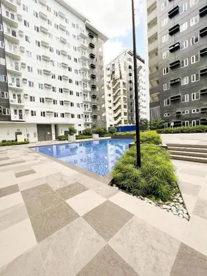 a pool in the middle of a courtyard with buildings at RoVi,s Nook SMDC Charm in Manila