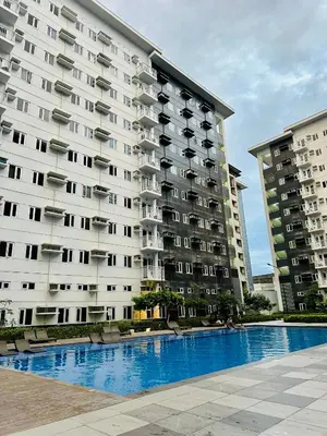 a large apartment building with a pool in front of it at RoVi,s Nook SMDC Charm in Manila