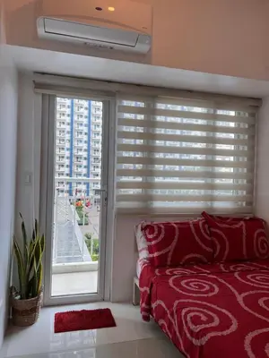a bedroom with a bed and a large window at Studio Units at SM Light Residences Condo Beside Boni MRT Station in Manila