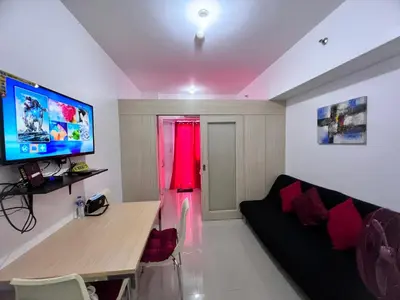 a living room with a couch and a red curtain at Studio Units at SM Light Residences Condo Beside Boni MRT Station in Manila
