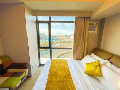 a hotel room with a bed and a large window at Lovely 1BR near Solaire, Okada I 5mins to Airport in Manila