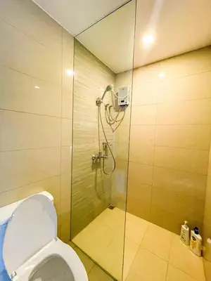 a bathroom with a shower with a toilet at Lovely 1BR near Solaire, Okada I 5mins to Airport in Manila