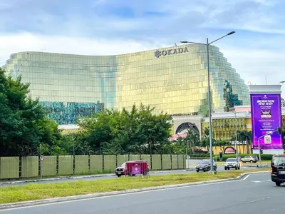 a large building with a sign on the side of a road at Lovely 1BR near Solaire, Okada I 5mins to Airport in Manila