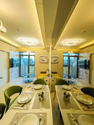 a dining room with tables and green chairs at Lovely 1BR near Solaire, Okada I 5mins to Airport in Manila