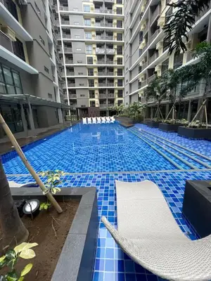 a large swimming pool with blue tiles in a building at Lovely 1BR near Solaire, Okada I 5mins to Airport in Manila