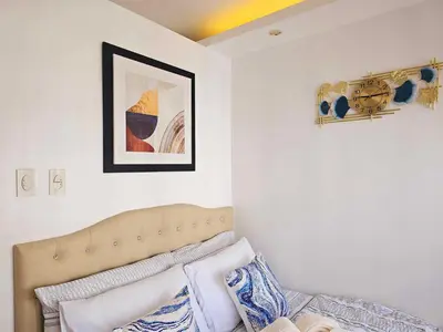 a living room with a couch and a picture on the wall at Hannah's Crib at Shore Residences with Balcony and Pool View in Manila