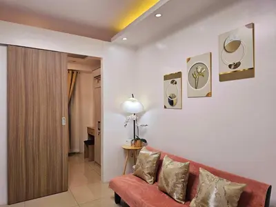 a living room with a red couch and paintings on the wall at Hannah's Crib at Shore Residences with Balcony and Pool View in Manila