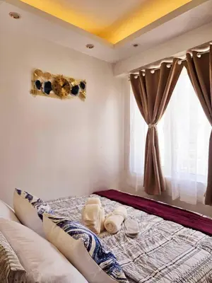 a bed in a room with a window at Hannah's Crib at Shore Residences with Balcony and Pool View in Manila