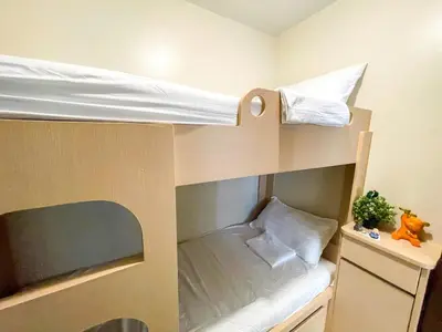 a small room with two bunk beds and a plant at Lovely 2br near Airport, Solaire, & Okada - 6pax in Manila