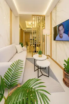 a living room with a white couch and a tv at Stylish & Cozy 1 bedroom near Mall of Asia in Manila