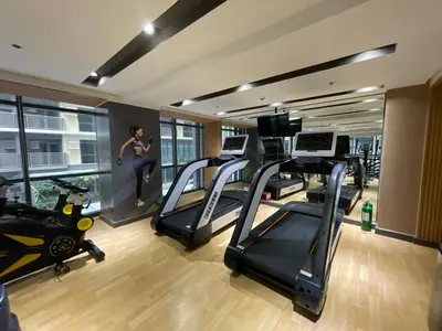 a gym with treadmills and a woman on a treadmill at Lovely 2 bedroom near Airport & Okada in Manila