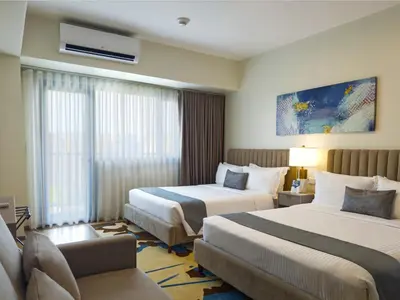 a hotel room with two beds and a couch at Savea Bay City Manila in Manila
