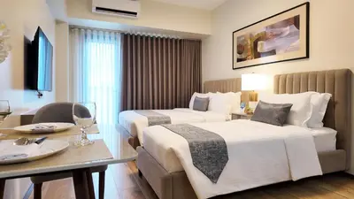 a hotel room with two beds and a table at Savea Bay City Manila in Manila