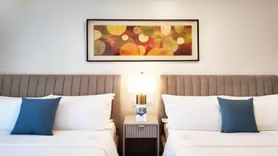 a bedroom with two beds and a picture on the wall at Savea Bay City Manila in Manila