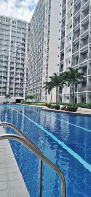 a large swimming pool in front of a large building at Shore Residences Near Moa in Manila