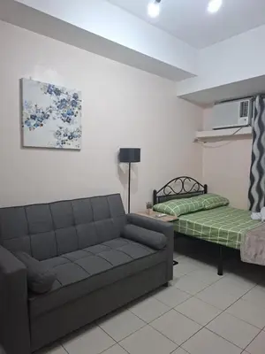 a living room with a couch and a bed at The Grand Towers Manila in Manila