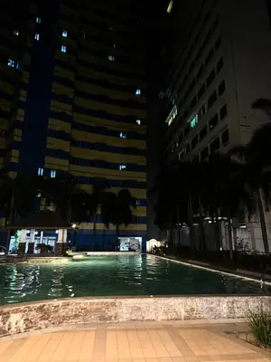 a swimming pool at night with tall buildings at The Grand Towers Manila in Manila