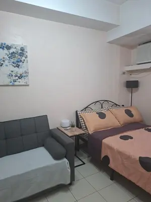 a living room with a bed and a couch at The Grand Towers Manila in Manila