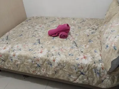 a bed with a pink towel on top of it at MOA Sea Residences Condotel in Manila