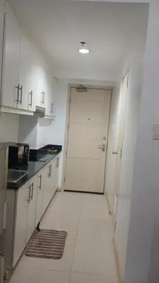 a kitchen with a white door and a white tile floor at MOA Sea Residences Condotel in Manila