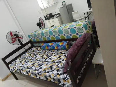 a bed with colorful sheets and pillows in a room at MOA Sea Residences Condotel in Manila