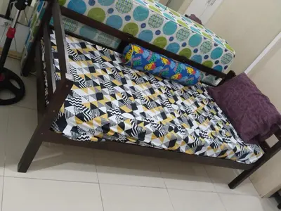 a futon bed with a patterned blanket on it at MOA Sea Residences Condotel in Manila