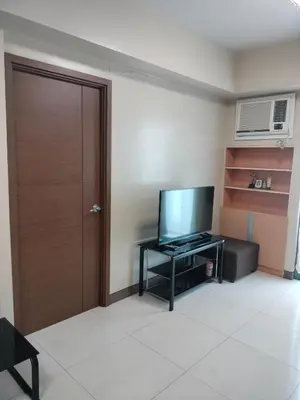 a room with a door and a television on a table at Rqui Family Room Pasay City in Manila