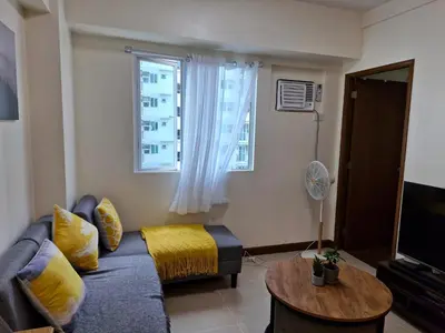 a living room with a couch and a television at Your 2BR within Pasay in Manila