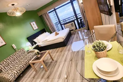 a living room with a couch and a bed and a table at Green City View Apt in Gramercy Unit 3502 Makati w Netflix in Manila