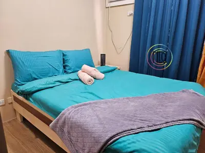 a bed with two pillows on top of it at Cozy 2BR UnitN Free Pool Gym with Karaoke Netflix in Manila