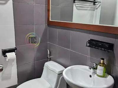 a bathroom with a sink and a toilet and a mirror at Cozy 2BR UnitN Free Pool Gym with Karaoke Netflix in Manila