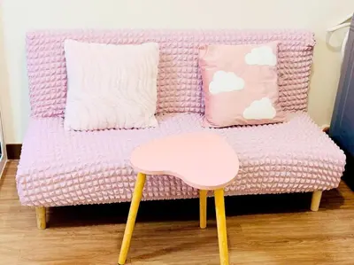 a pink couch with a stool and pillows at Boogsh Coquette Vibes Staycation In Pasig! in Manila