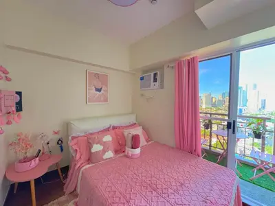 a bedroom with a pink bed and a large window at Boogsh Coquette Vibes Staycation In Pasig! in Manila