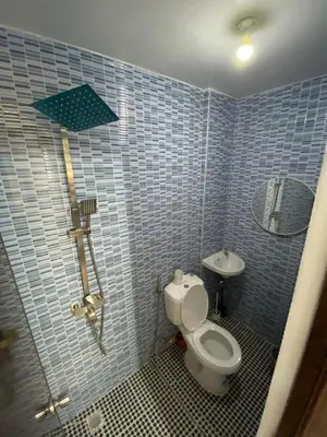a blue tiled bathroom with a toilet and a sink at Cabuhat Duco Lodge 31 in Tanza
