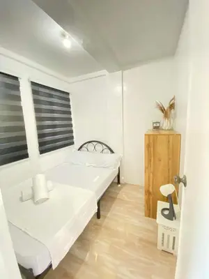 a white room with two beds and a window at Cabuhat Duco Lodge 31 in Tanza