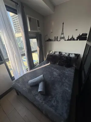 a bedroom with a bed with the eiffel tower on the wall at Sentinel Residences 1 bedroom partition in Manila