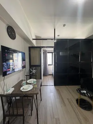 a living room with a table and a clock on the wall at Sentinel Residences 1 bedroom partition in Manila