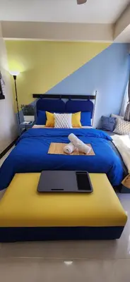 a blue bed with a tablet on top of it at 14e BGC Unit 3 mins Walk to The Venice Grand Canal Mall Pet Friendly in Manila