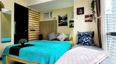 a small bedroom with a bed and a pillow at 2 Unique Side-by-Side Studios Vibrant & Zen at Viceroy BGC in Manila
