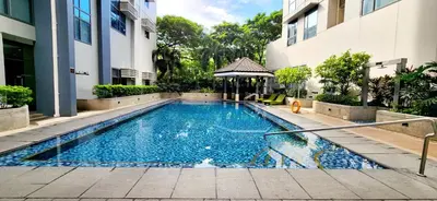 a swimming pool in front of a building at 2 Unique Side-by-Side Studios Vibrant & Zen at Viceroy BGC in Manila