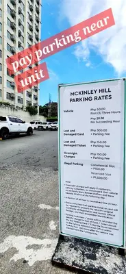 a sign on the side of a street with a parking lot at 2 Unique Side-by-Side Studios Vibrant & Zen at Viceroy BGC in Manila