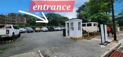 a sign that reads entrance next to a parking lot at 2 Unique Side-by-Side Studios Vibrant & Zen at Viceroy BGC in Manila
