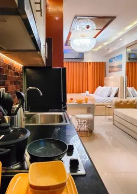 a kitchen with a sink and a living room at Shore 2 Reminisce in Manila