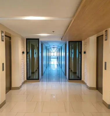 an empty hallway in a building with glass doors at Shore 2 Reminisce in Manila